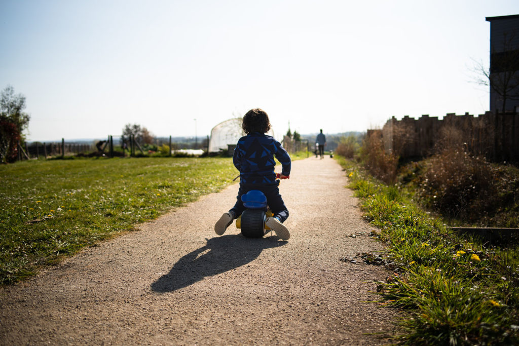 Reportage du quotidien près de Rennes. photographie représentant un enfant de dos en contre-jour sur son vélo.