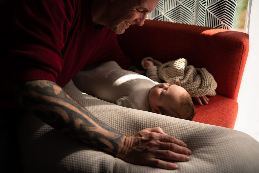 Reportage du quotidien près de Rennes. Photographie couleur d'un papa communiquant avec son bébé.
