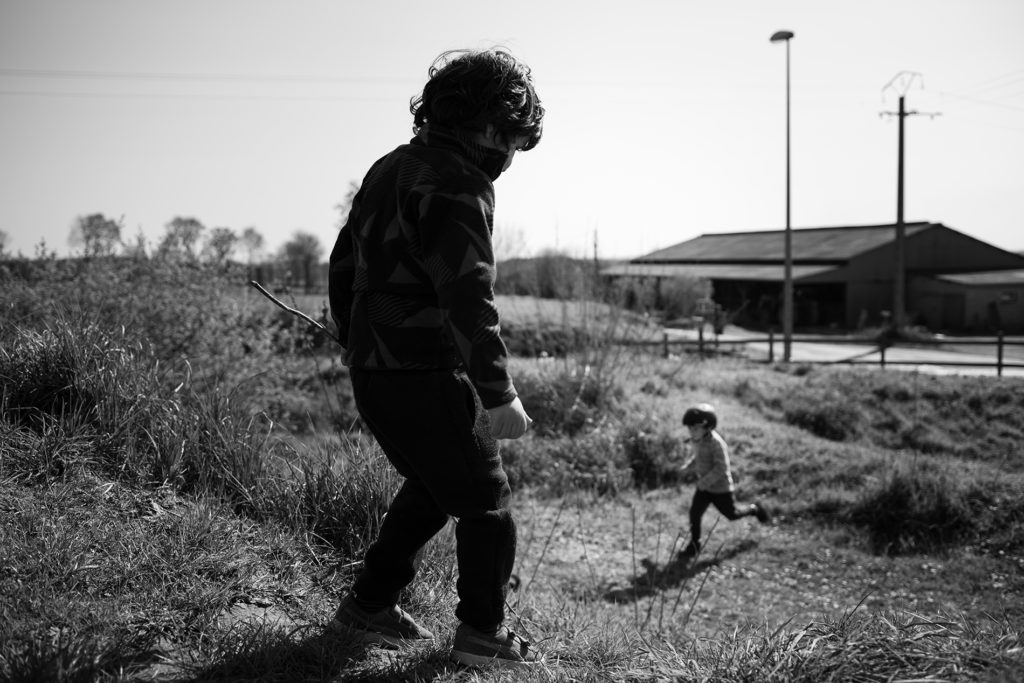 Reportage du quotidien près de Rennes. Photographie noir et blanc d'enfants jouant dehors.
