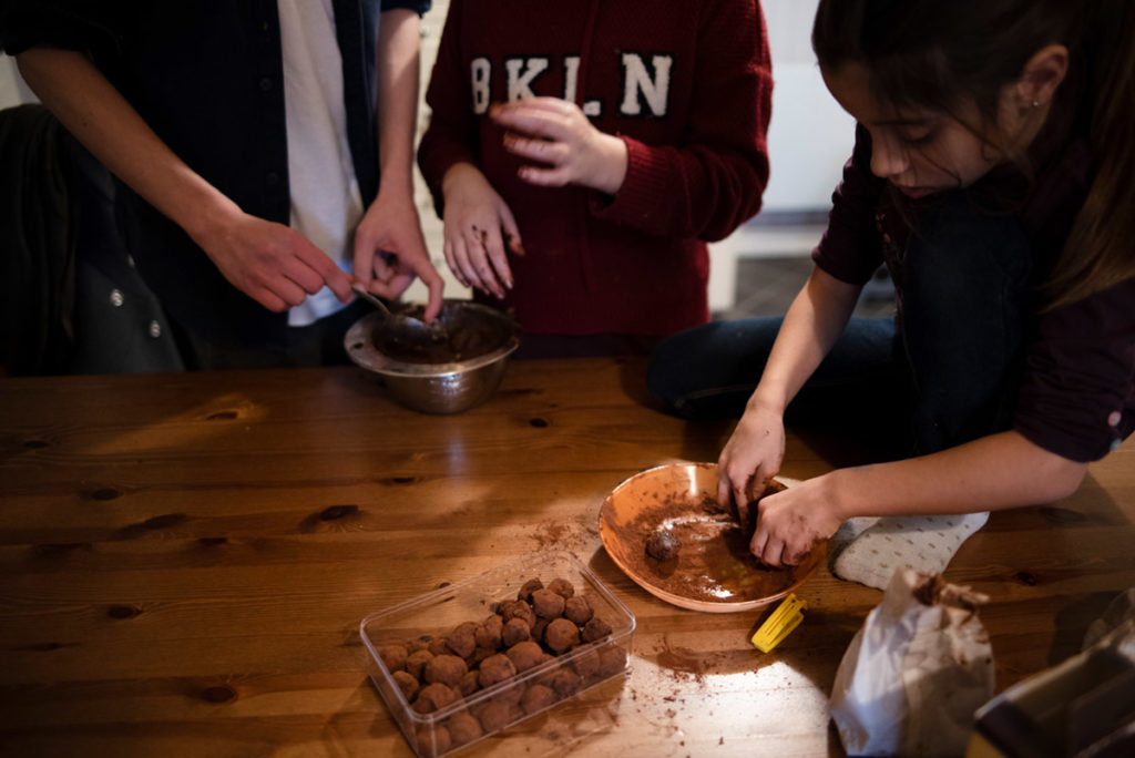 Offre reportage découverte. Photographie d'un reportage de famille autour de Noël. Des enfants préparent des truffes au chocolat. Photographe Pascaline Michon.