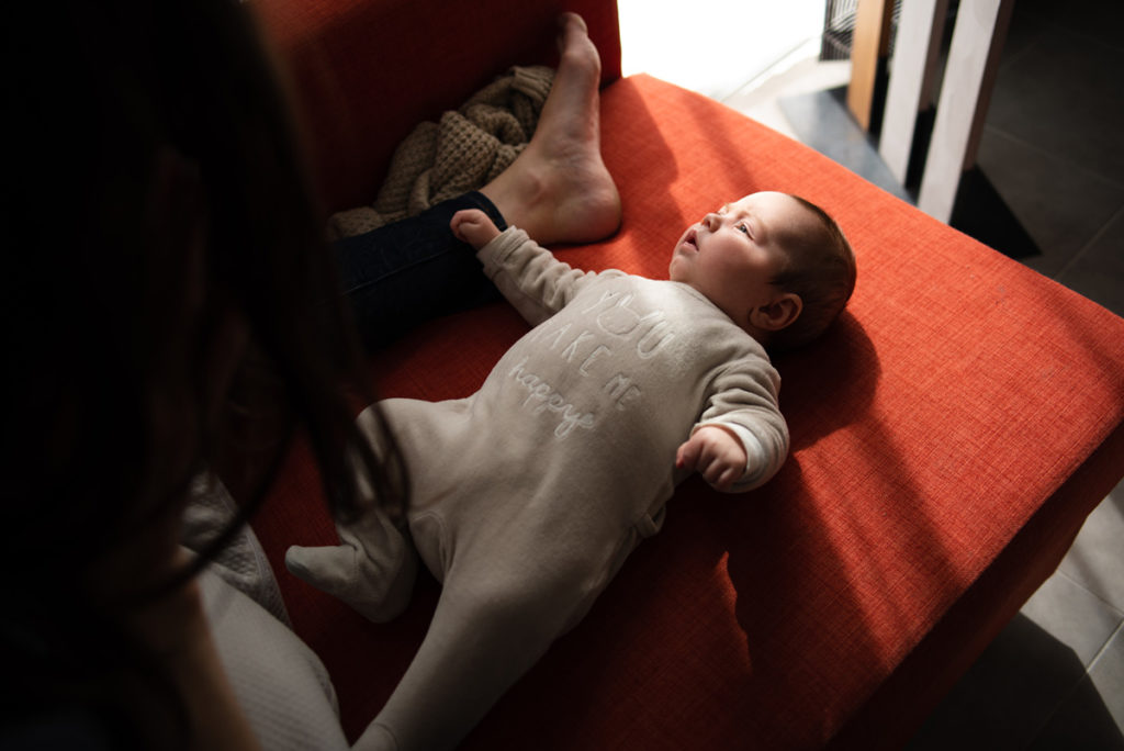 Rétrospective 2019, mes photos préférés ! Reportage de famille à Rennes, portrait d'un bébé sur le canapé, on devine sa maman au dessus. Photographe Pascaline Michon.