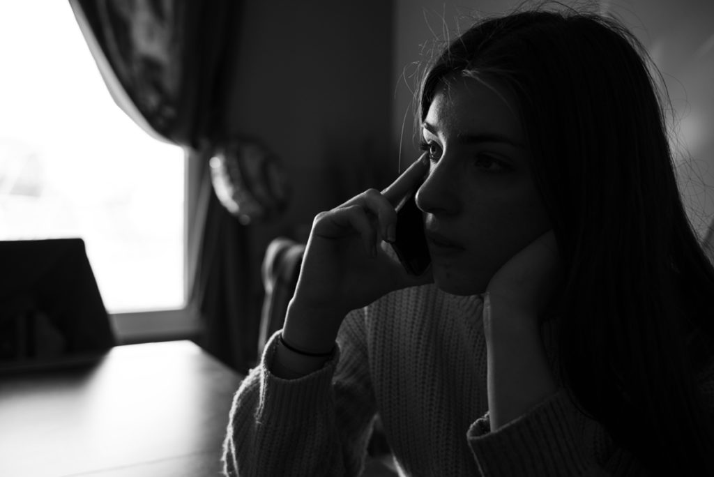 Rétrospective 2019, mes photos préférés ! Reportage de famille dans la Sarthe. Portrait en noir et blanc d'une jeune fille au téléphone. Photographe Pascaline Michon.